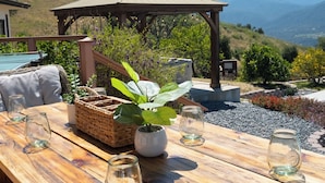 A wooden dining table with chairs, a pergola, and a view of mountains. - Mountain Retreat, Pool+Great Views, 30 days (Carmel Valley)