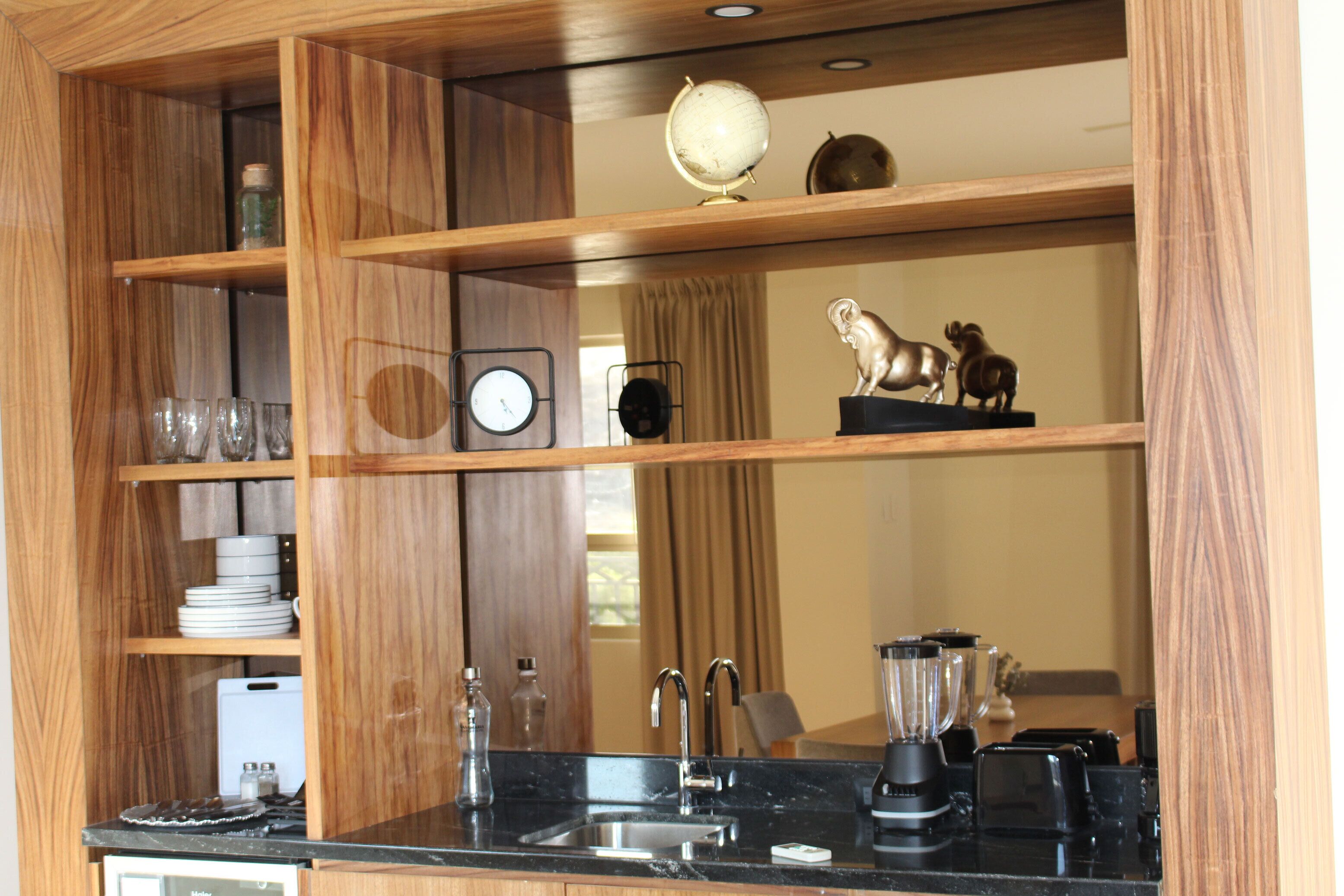 Una cocina con estantes de madera, un lavamanos, un reloj y un globo terráqueo.