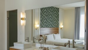 Een moderne badkamer met twee wastafels, een grote spiegel en een houten wastafelmeubel.