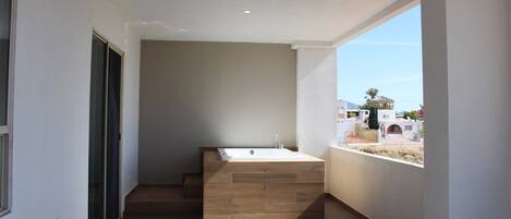Un baño moderno con una bañera independiente, un ventanal y vistas del entorno.