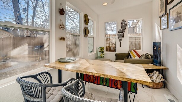 A modern interior with a dining area, a sofa, and a fireplace. - Quiet 2 BR near RiNo w/ sunroom & large backyard (Denver)