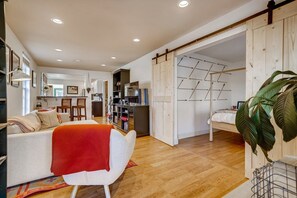 A modern living room with a sofa, a coffee table, and a dining area with chairs.
