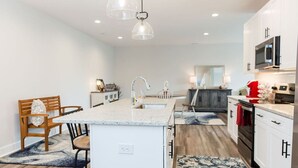 A modern kitchen with white cabinetry, a granite countertop, and stainless steel appliances. - Stoney Ridge · Cozy 1st Level King Bed Suite - 2 bed 2 bath! (Forest)