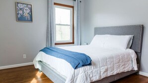 A bedroom with a bed, a window, and a painting on the wall. - Charming Single Level Home • Convenient 3 Bedroom (Lynchburg)