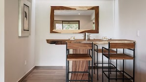 A kitchen with a wooden countertop, two bar stools, a sink, and a mirror above the counter. - Moderna Villa con Hermosa Vista al Lago (Valle de Bravo)