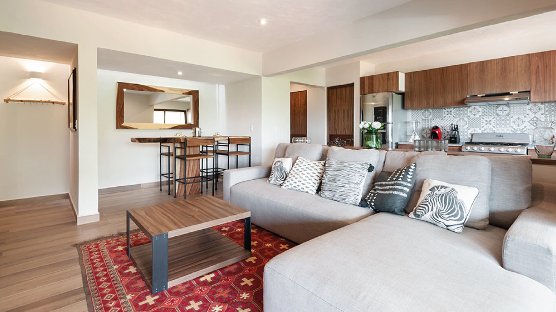 A modern living room with a sofa, coffee table, and a dining area with chairs.
