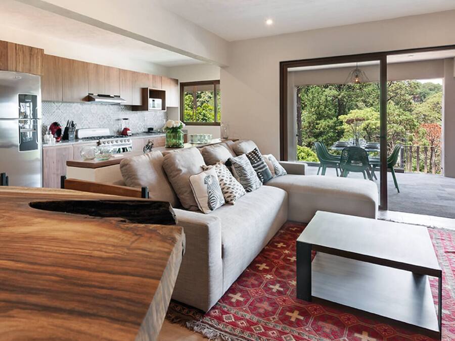 A modern kitchen with a built-in oven and a dining area with a wooden table and chairs.