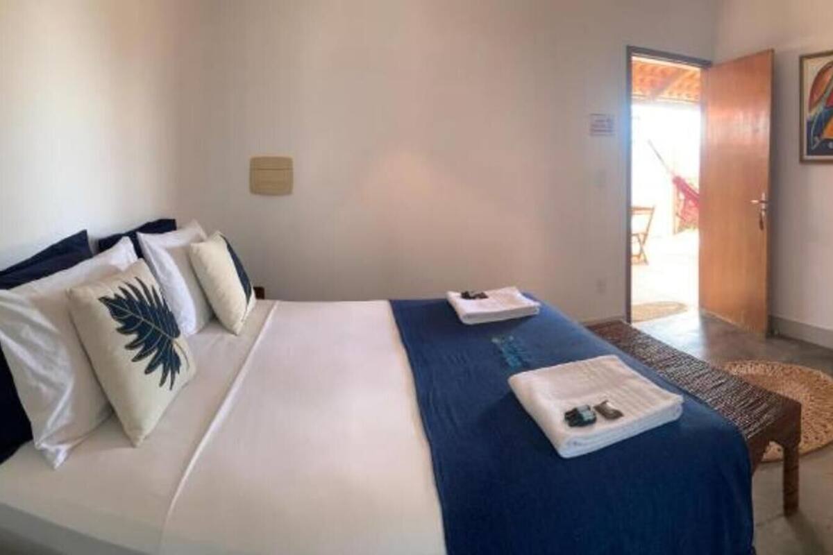 Une chambre d’hôtel avec un lit, un petit bureau, une salle de bain et un tableau au mur.