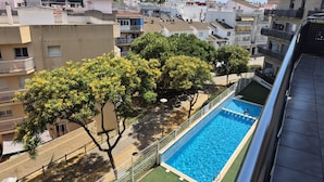 Zona residencial con piscina, árboles y edificios.