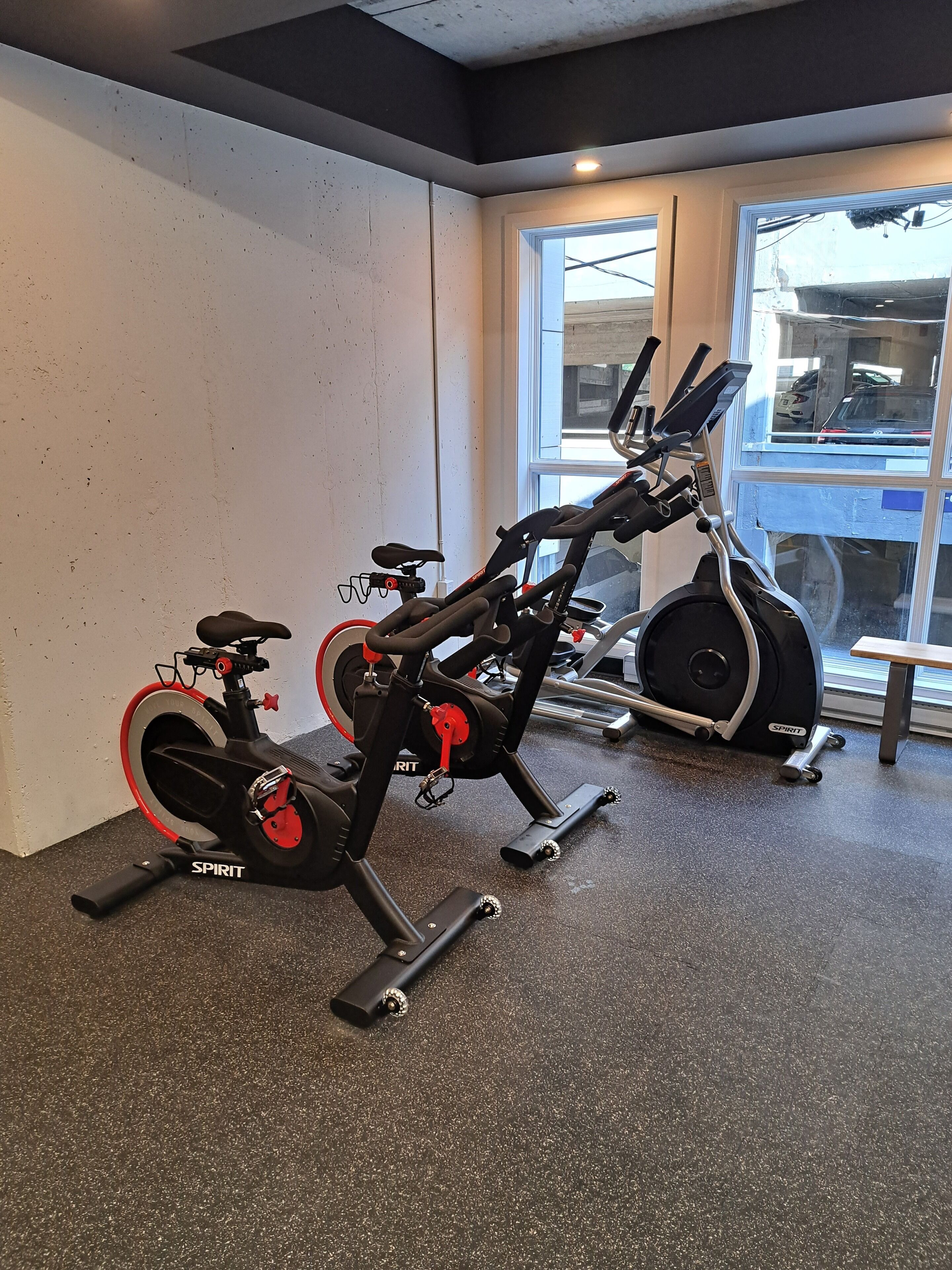 Un gimnasio con bicicletas estáticas y vistas al exterior.
