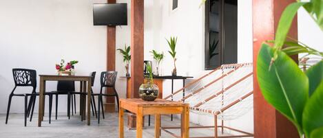 A cozy outdoor seating area with a wooden table, chairs, and a hammock.