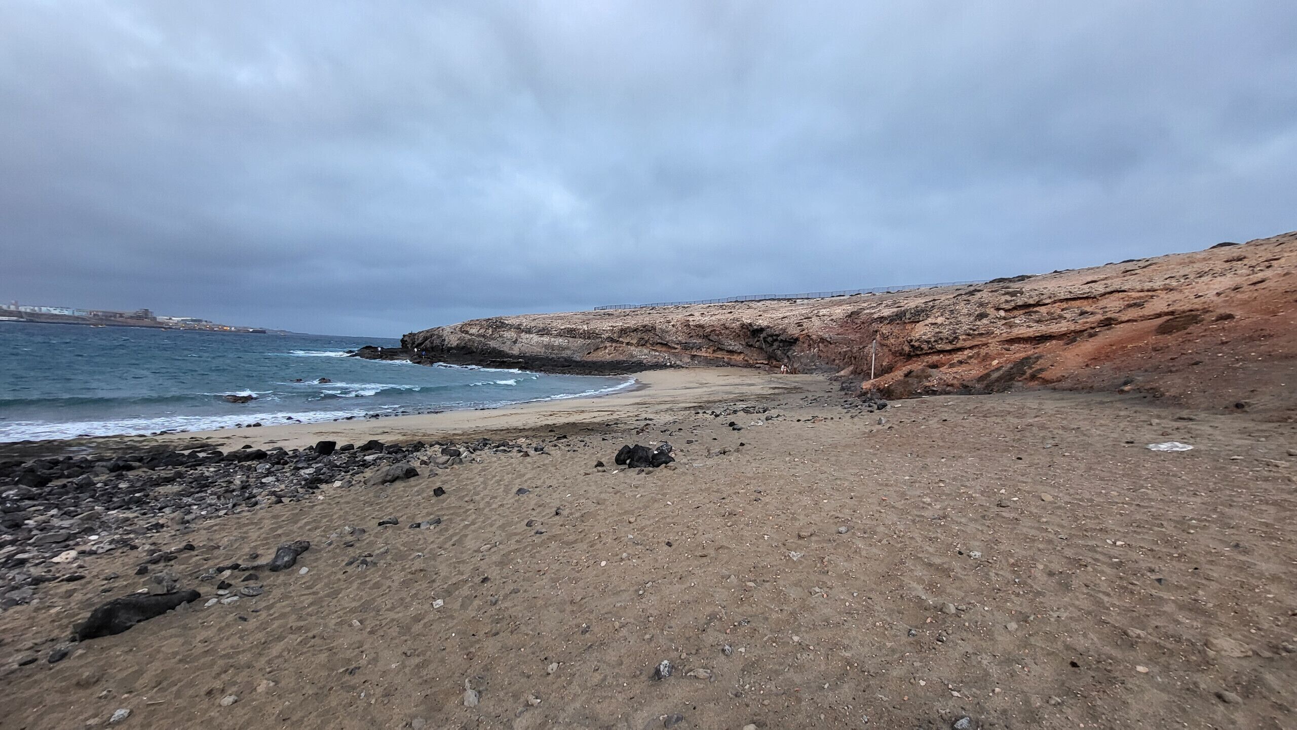 Een rotsachtige kustlijn met een rotswand en uitzicht op de oceaan.