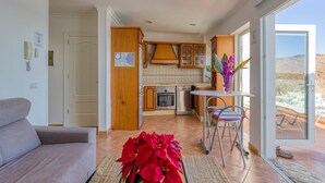 A compact living space with a kitchenette, a dining area with a table and chairs, and a sofa. - Tufia Marine Life by Canariasgetaway (Telde)