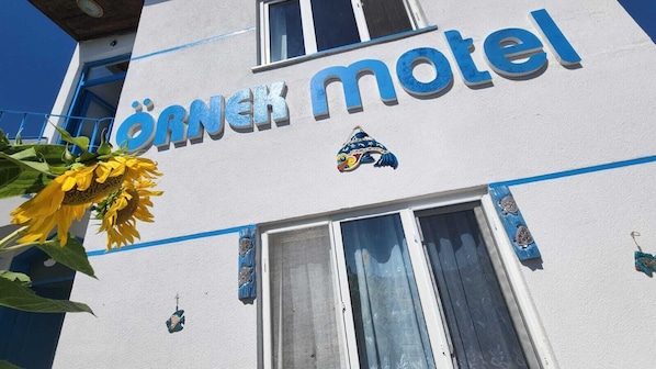 A building with the sign 'Jornek motel' and a decorative emblem above the entrance.