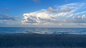 Une plage avec un ciel dégagé et une mer calme.
