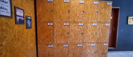 A row of wooden lockers with numbered labels, a Buddha statue, and motivational posters on the wall.