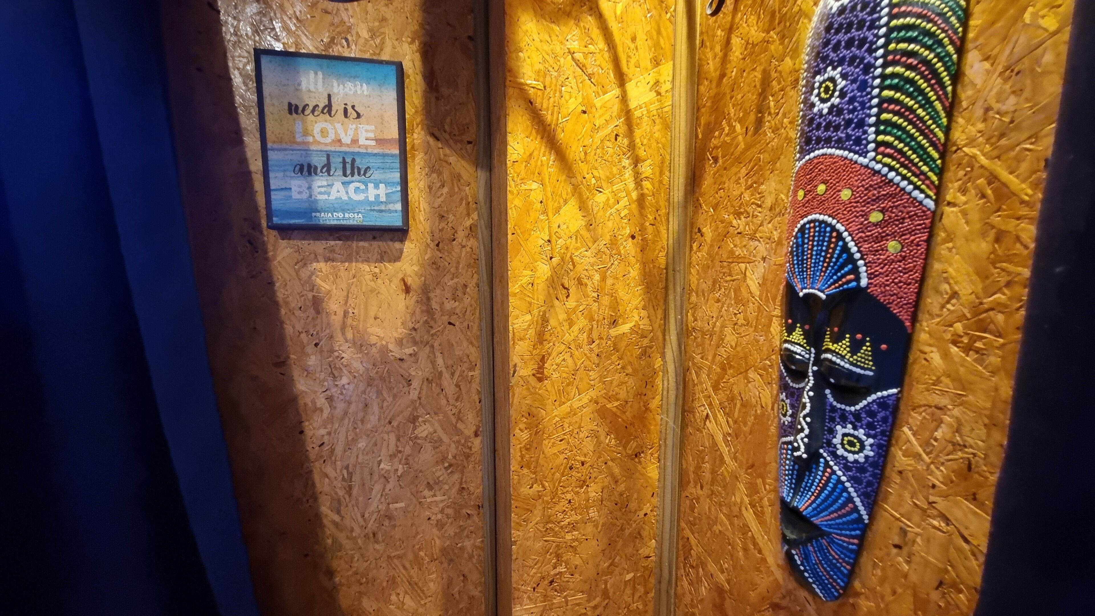 A wall with a framed quote, a textured wall, and a colorful artwork.