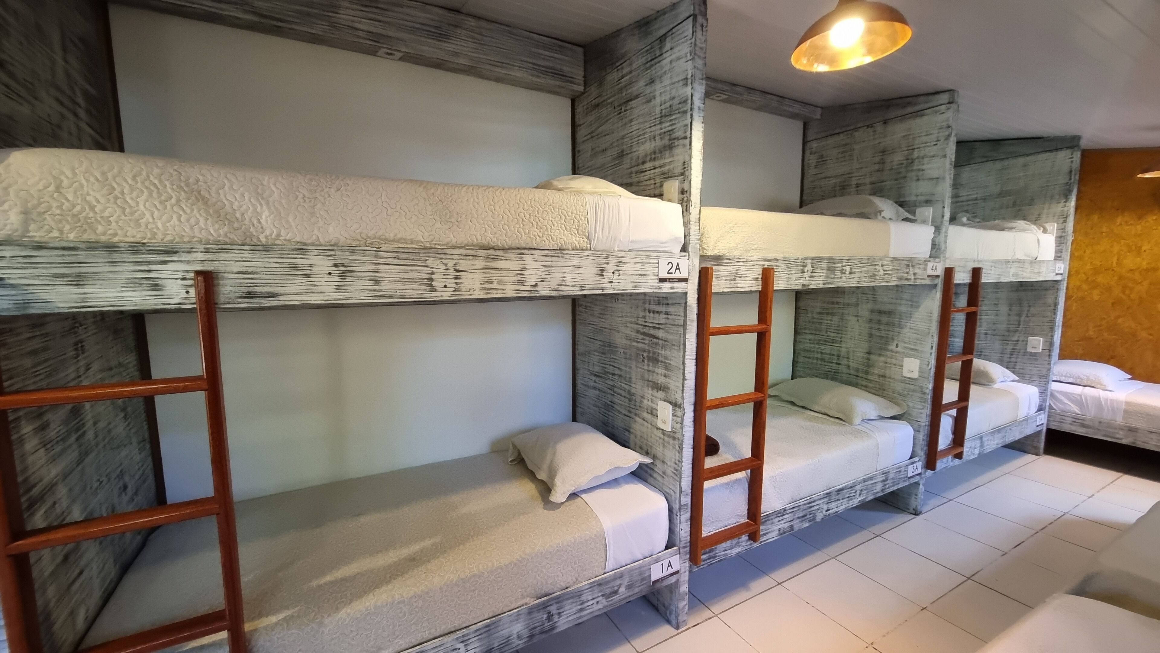 Un dormitorio con literas, escaleras de madera y un diseño sencillo y funcional.