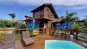 A wooden villa with a pool, deck, and a mural on the side. - Arte da Tribo Hsotel & Camping - Hostel (Imbituba)