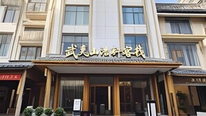 A hotel with a sign in a foreign language, large windows, and a traditional entrance. - Haoxuan Inn (Wuyishan)