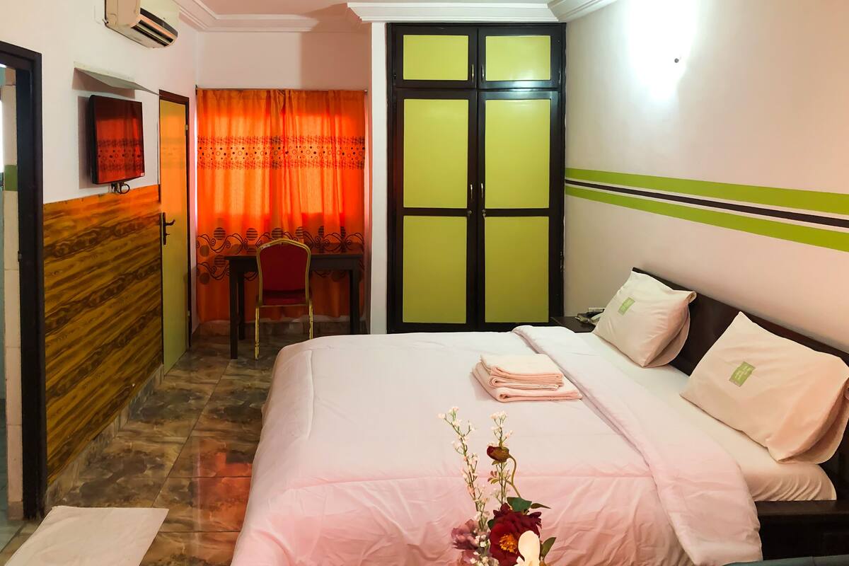 A hotel room with a bed, a desk, and a chair.