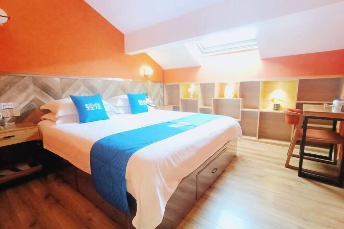 Une chambre d’hôtel avec un grand lit, un bureau et une chaise.