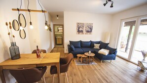 A modern living room with a wooden dining table, two sofas, and a coffee table.