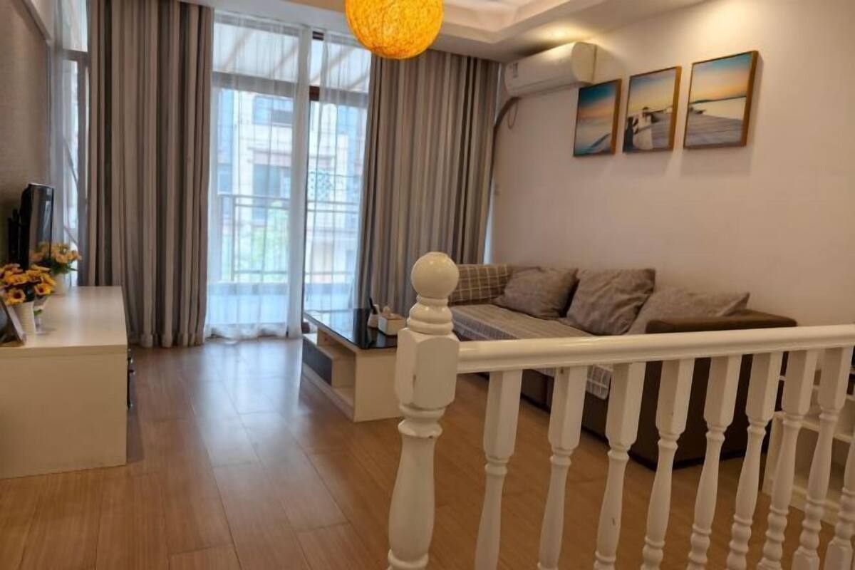 Ein modernes Wohnzimmer mit einer Couch, einem Esstisch und einer Treppe.