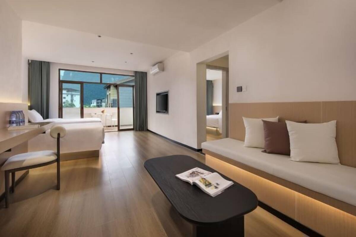 Ein modernes Hotelzimmer mit Bett, einer Couch, einem Schreibtisch und einem Fernseher.