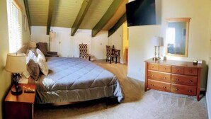 A bedroom with a bed, dresser, and a television.