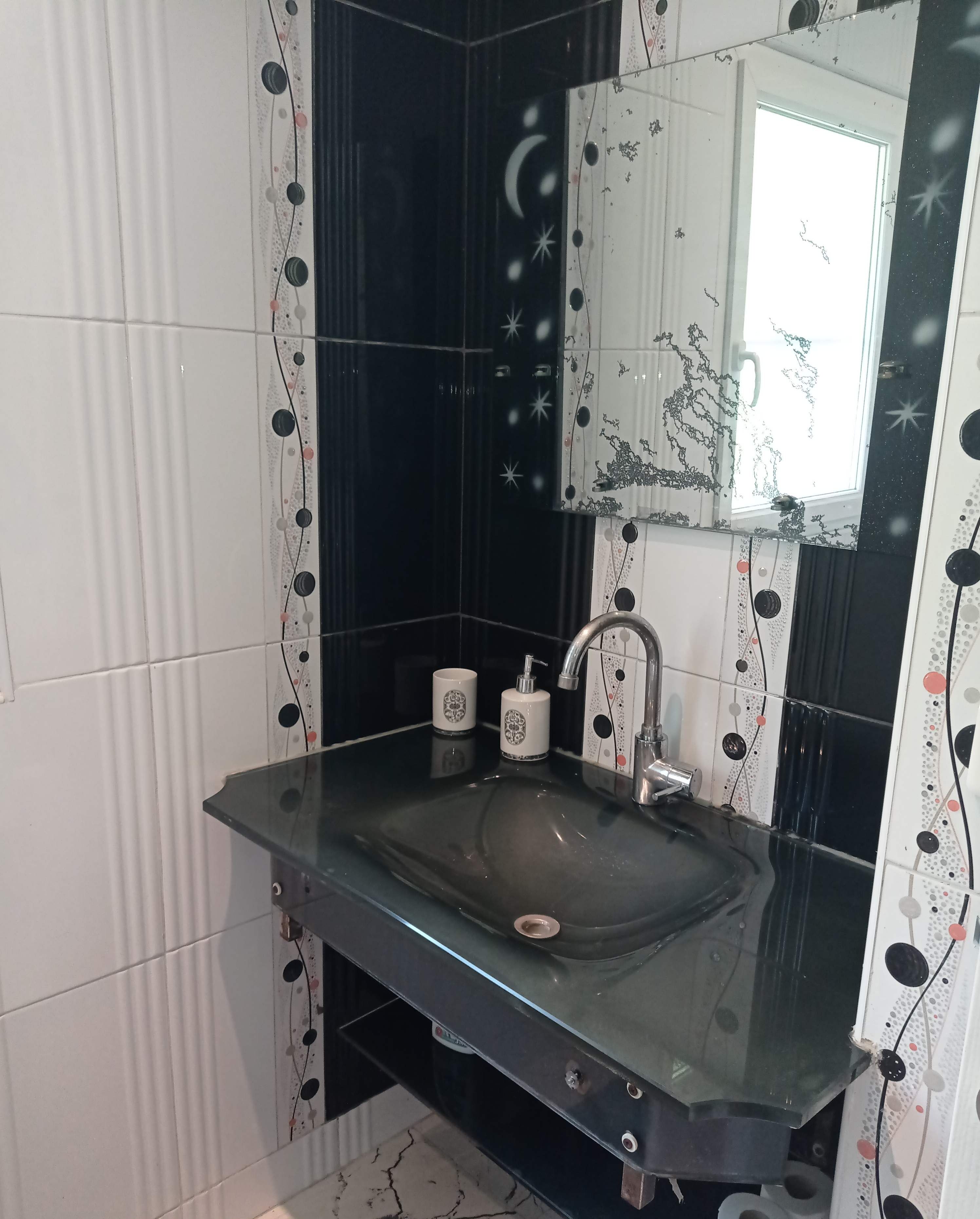 Et badeværelse med vask af glas, et spejl og et toilet.
