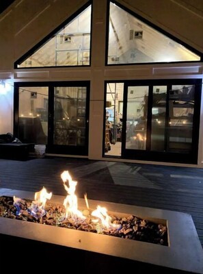 Experience the warmth of a cozy fire feature in a modern outdoor space with expansive views.