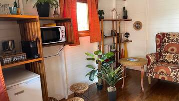 A compact living space with a kitchenette, a dining area, and a seating area.