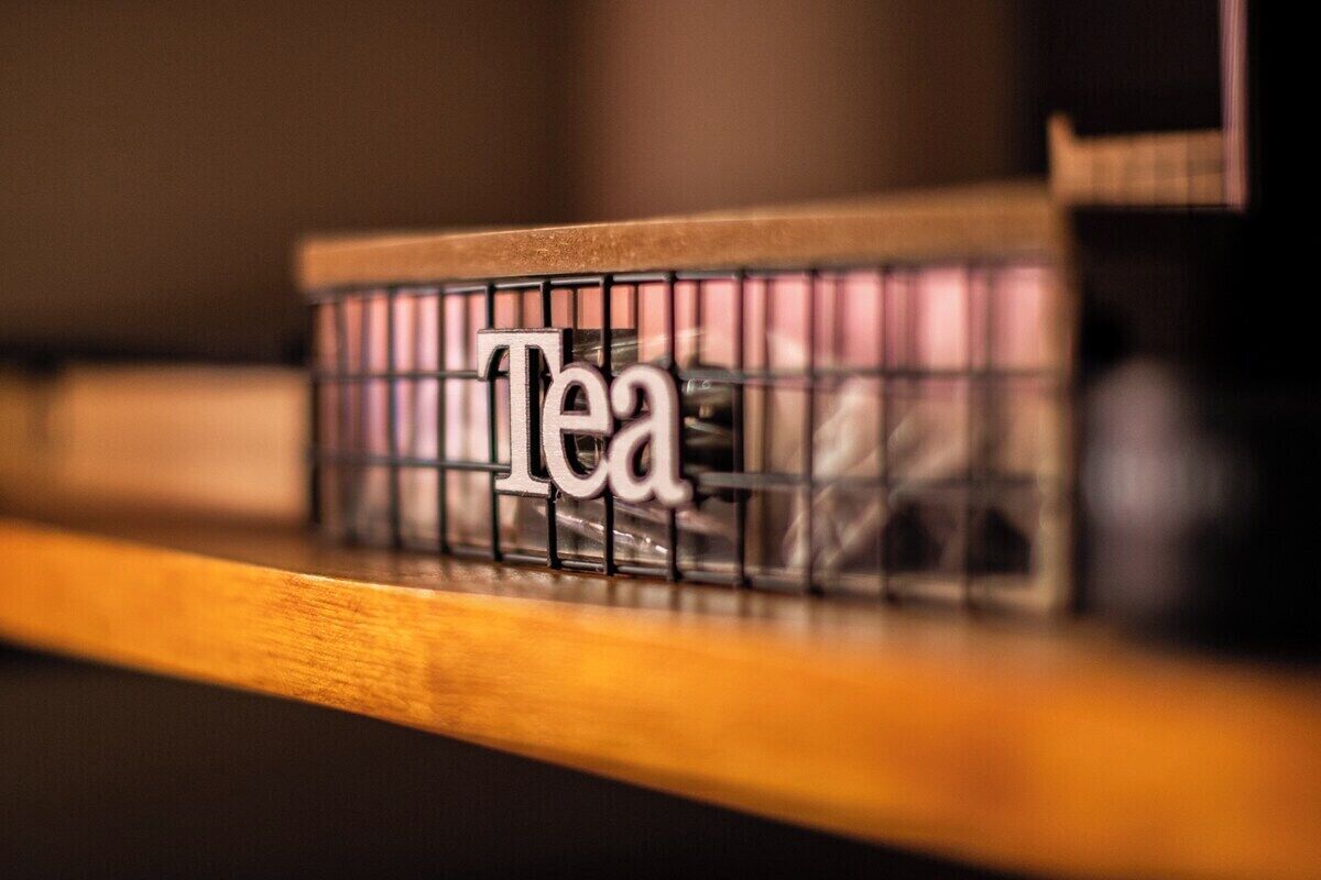 Ein Regal mit einem Metalldrahtgitter, auf dem das Wort 'Tea' steht.