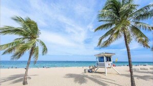 A beach with palm trees and a lifeguard tower.