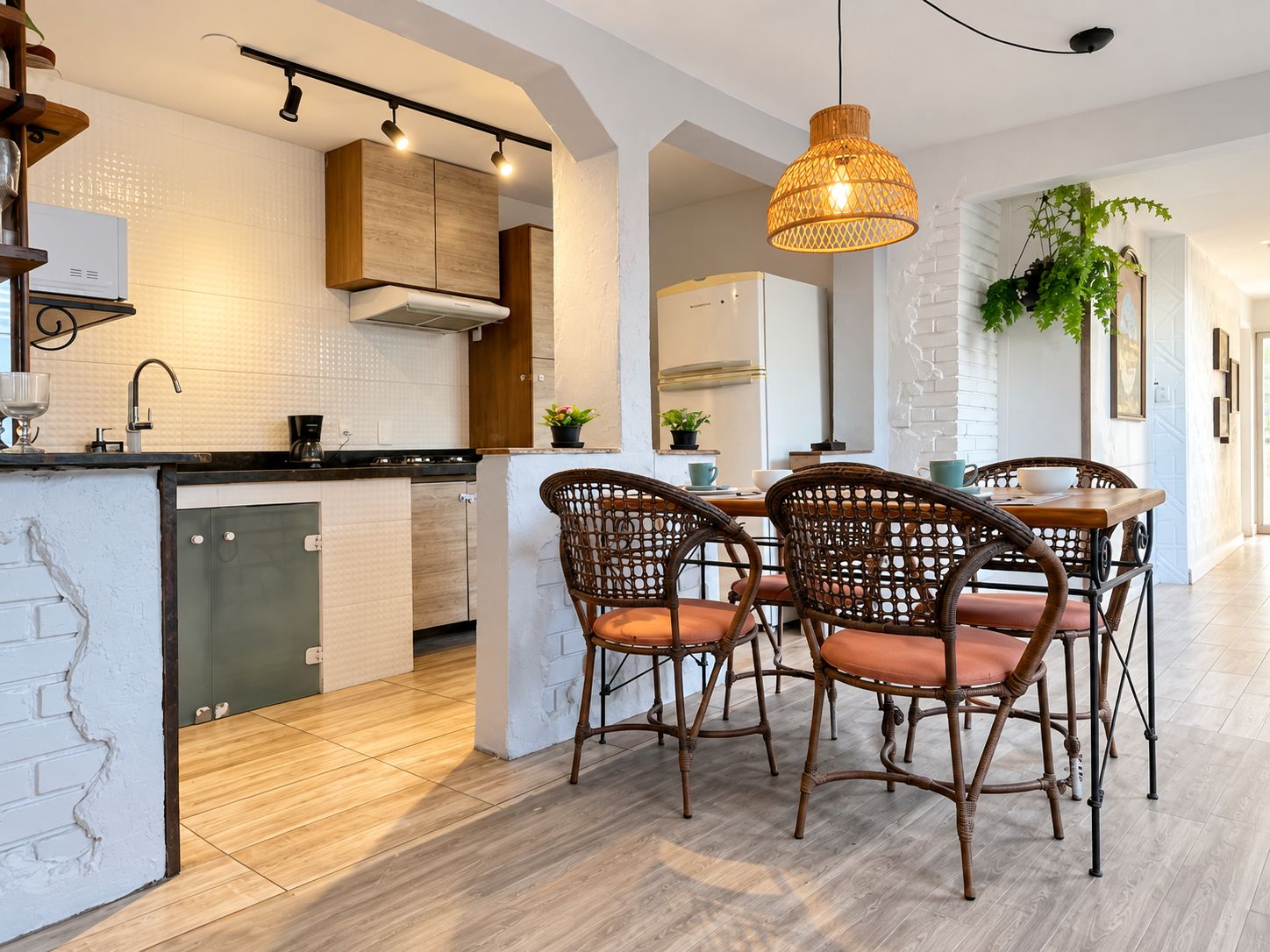 Una cocina moderna con una isla central, sillas de comedor y una lámpara colgante.