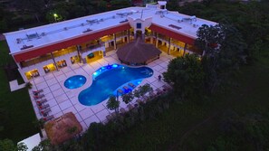 Un grand bâtiment moderne doté d’une piscine, de nombreux balcons et d’espaces de détente en plein air.