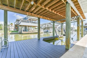 Enjoy a serene view of the surrounding water from this expansive deck, featuring a pool and comfortable seating.
