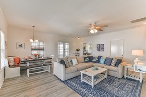 Relax in this inviting living room with a sofa, coffee table, and dining area.