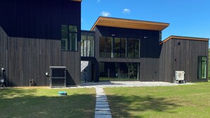 Une maison moderne à deux étages, avec un chemin en pierre menant à l’entrée.