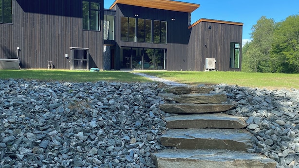 Un bâtiment moderne avec un chemin en pierre menant à l’entrée.