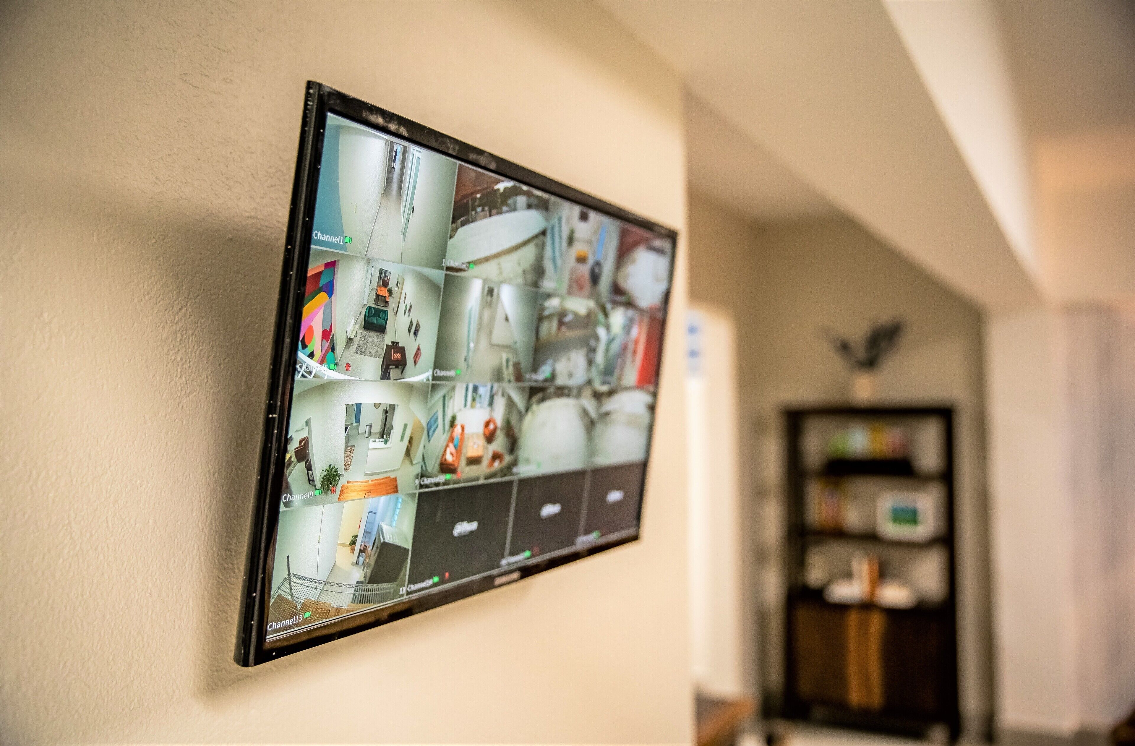 Sistema de cámaras de seguridad instalado en la pared que muestra varias escenas interiores.