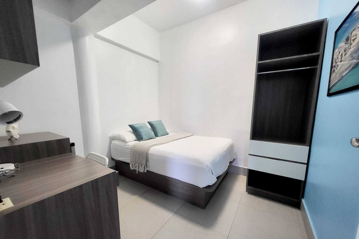 Ein modernes Schlafzimmer mit Bett, Nachttisch und Kleiderschrank.