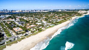 A coastal town with a beachfront, residential buildings, and a city skyline in the background. - Serenity Shores (Palm Coast)