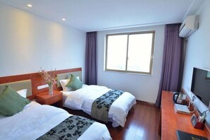 A hotel room with two beds, a wooden desk, a television, and a window with curtains. - Lixin Hotel (Guilin Sun Moon Twin Pagodas & Elephant Trunk Hill Scenic Area Branch) (Guilin)