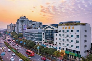 A multi-story hotel with a modern design, located in a busy urban area with a clear sky. - Lixin Hotel (Guilin Sun Moon Twin Pagodas & Elephant Trunk Hill Scenic Area Branch) (Guilin)
