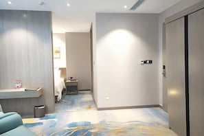 A hotel room with a bed, a desk, a trash bin, and a wardrobe. - Horgos Hotel (Khorgas)