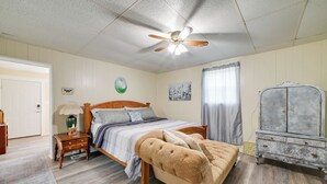 A bedroom with a wooden bed, a ceiling fan, a nightstand, a dresser, and a window with curtains. - Serene McEwen Cottage ~ 2 Mi to Golf Course! (McEwen)