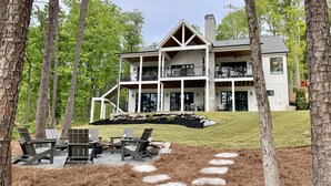 A large, two-story house with a covered porch, surrounded by trees and a well-maintained lawn. - Brand New 6BR/6BA Luxury, 20min to Clemson. Wooded flat lot/firepit/pool table! (West Union)