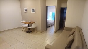 A compact room with a dining area, a bed, and a sofa. - Urquiza Suites Salta (Salta)